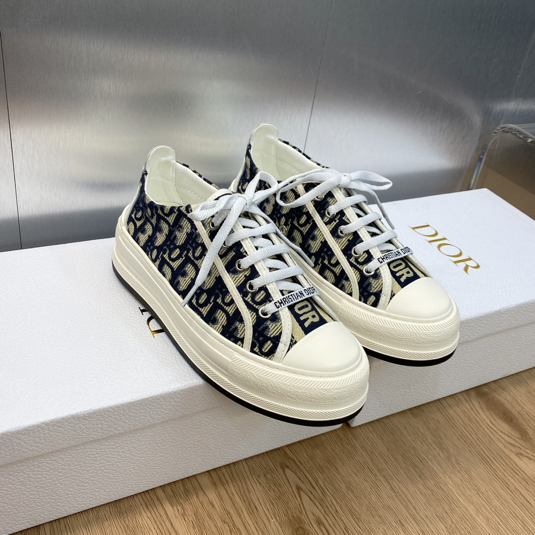 Navy blue monogram low-top sneakers with white laces and Dior-branded tongue.