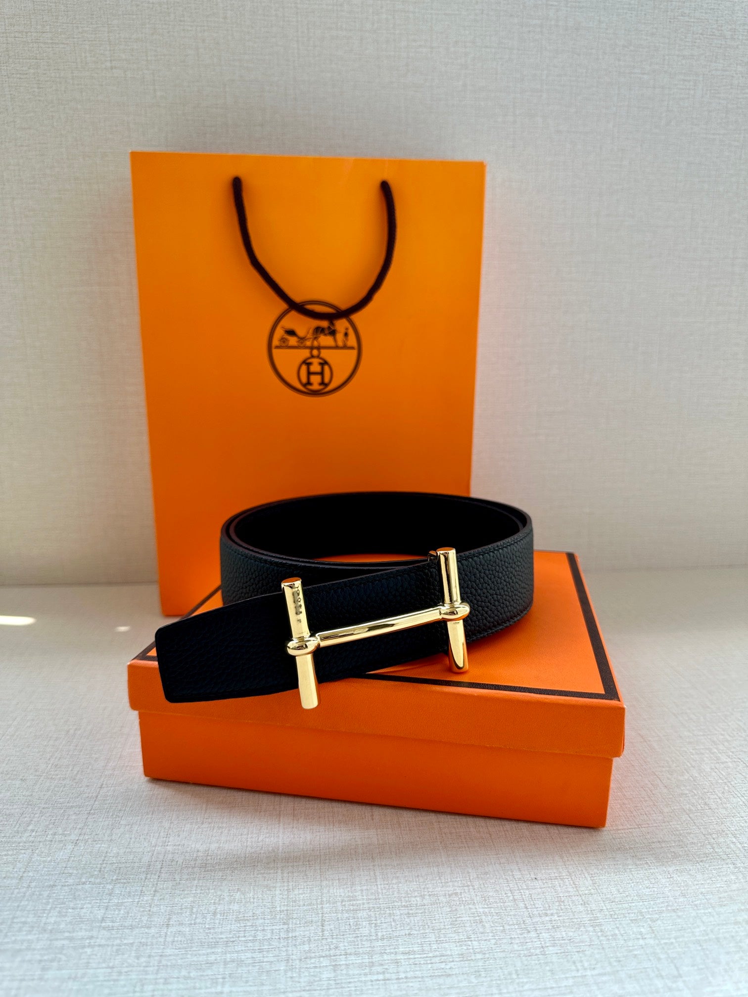 Hermes black leather belt with metal buckle, flat lay