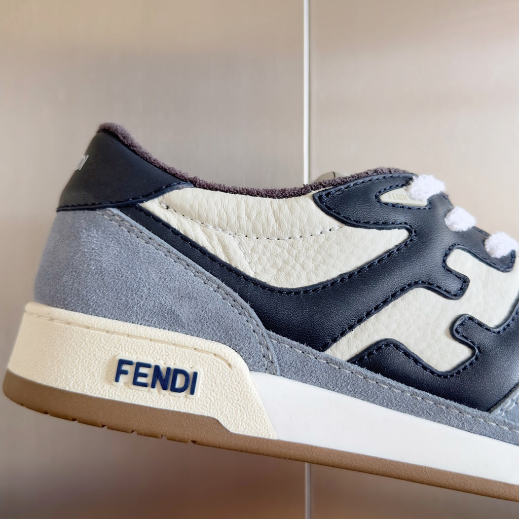 Fendi unisex sneaker upper close-up with light gray suede, white leather, navy accents
