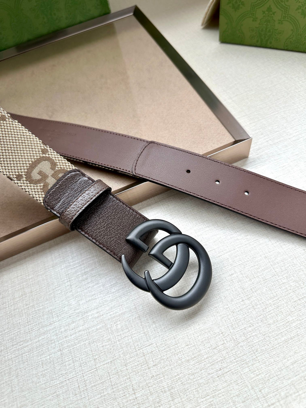 Gucci belt laid flat with brown leather strap and silver double G buckle