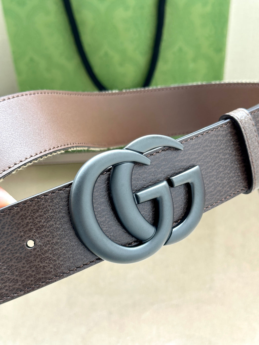 Gucci belt detail with gray leather strap and silver-tone double G buckle