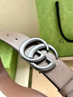 Gucci belt close-up: beige GG canvas with silver buckle and punched holes