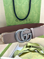 Gucci belt detail: taupe leather strap with silver double G buckle and pinholes