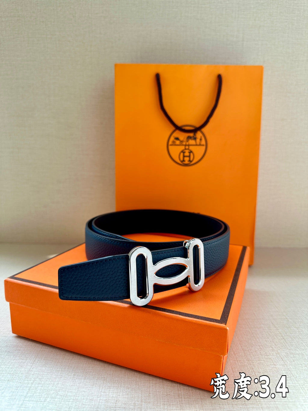 Hermes belt in dark blue leather with silver-tone buckle, centered view.
