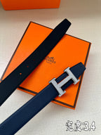 Dark blue leather belt with silver Hermès H buckle, laid flat with strap perforations