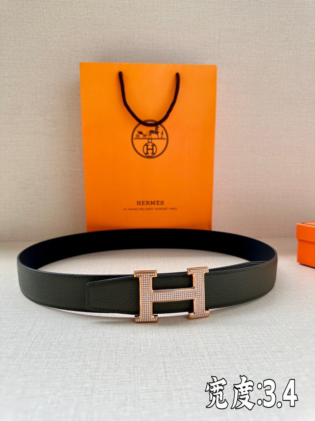 Hermes leather belt in dark green with studded H buckle, polished rose-gold tone.