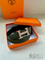 Hermes leather belt in dark green with jeweled H buckle, presented in gift box.