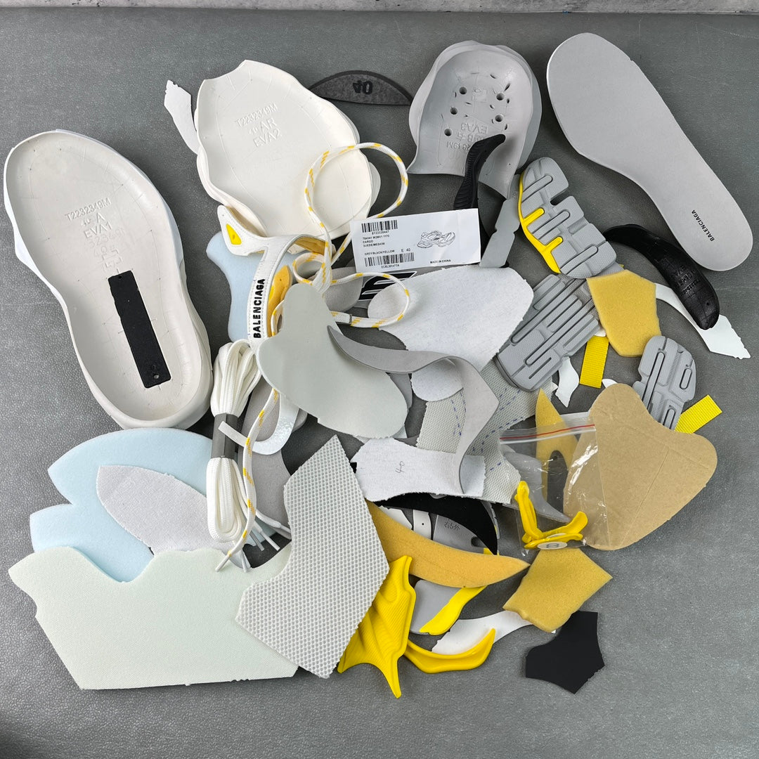 Balenciaga unisex sneakers laid out with spare insoles and yellow accents