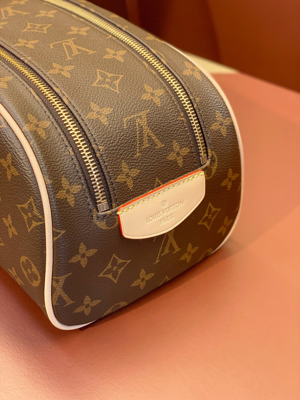 Louis Vuitton monogram toiletry bag corner view with leather trim and zipper