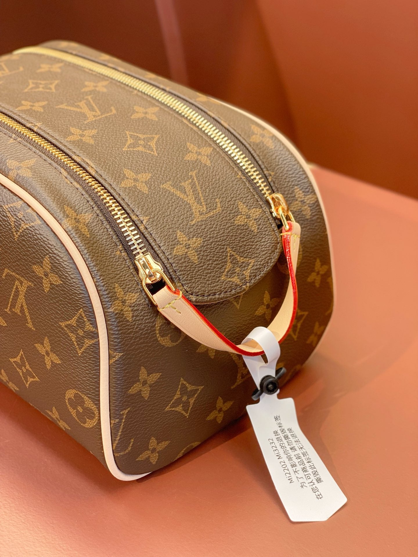 Louis Vuitton monogram toiletry bag with side zip track and red strap pull