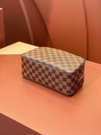 Louis Vuitton checkered toiletry bag with flat top and zip closure.