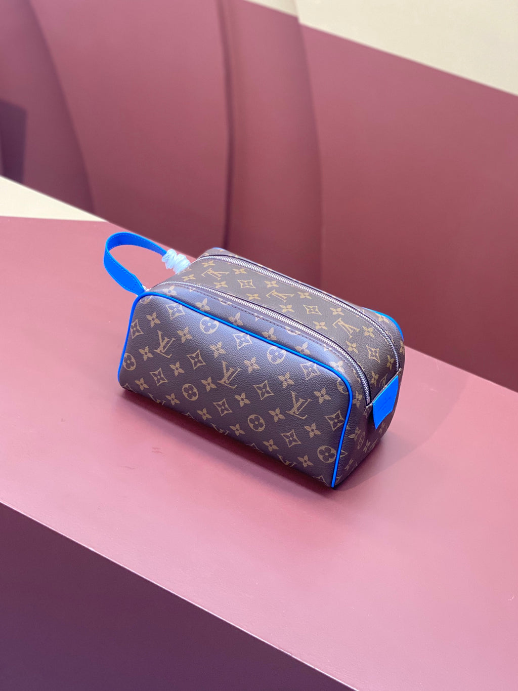 Louis Vuitton monogram canvas bag with blue trim and top zipper, side view