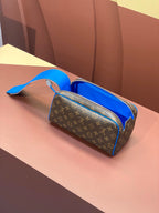 Louis Vuitton monogram bag with blue leather handle, structured top, side angle