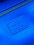 Blue leather label on Louis Vuitton monogram bag near the top zipper seam