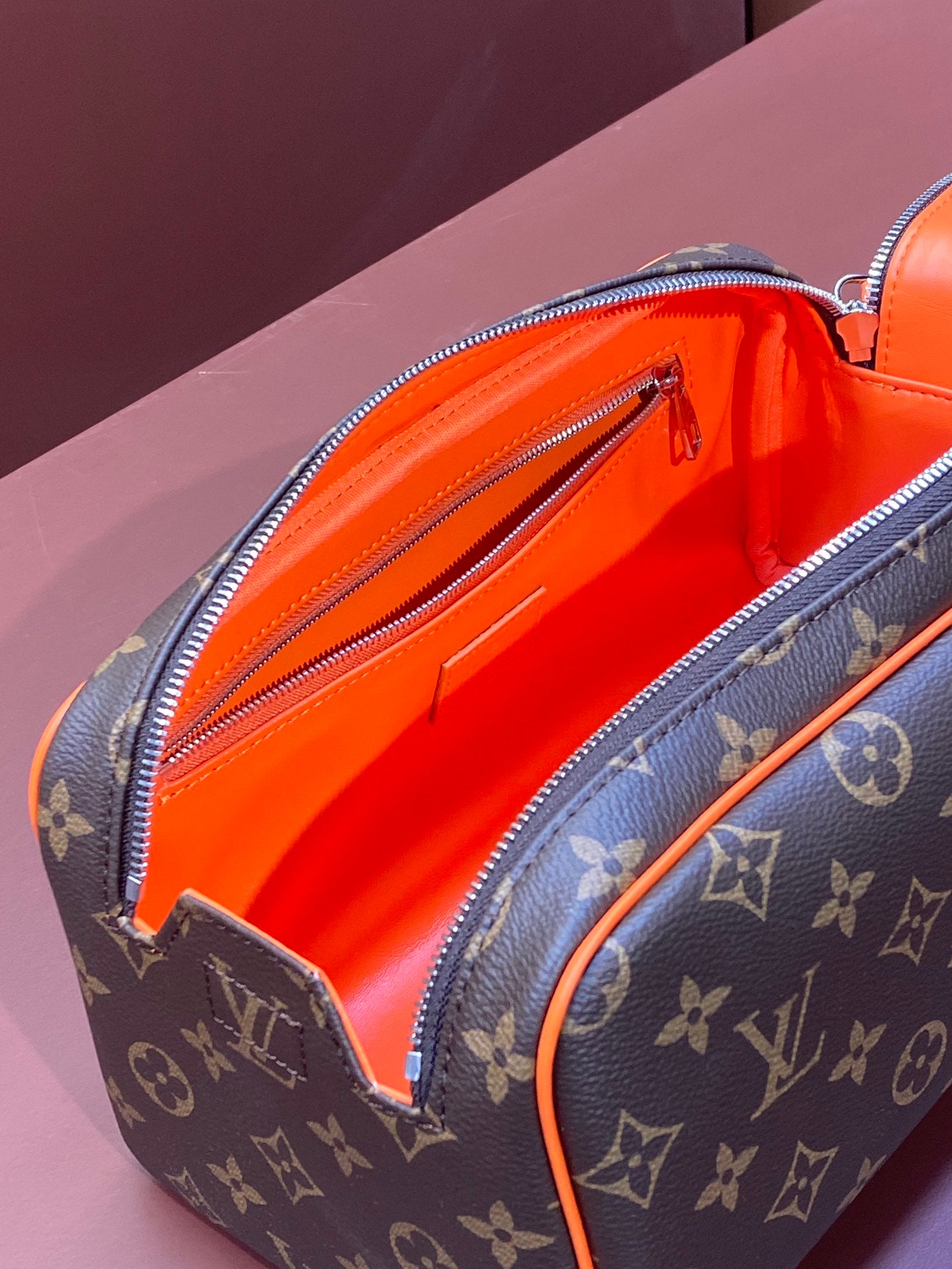Louis Vuitton monogram bag interior with bright orange lining and zip pocket