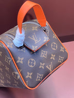 Louis Vuitton monogram bag with orange handle and side pull tabs