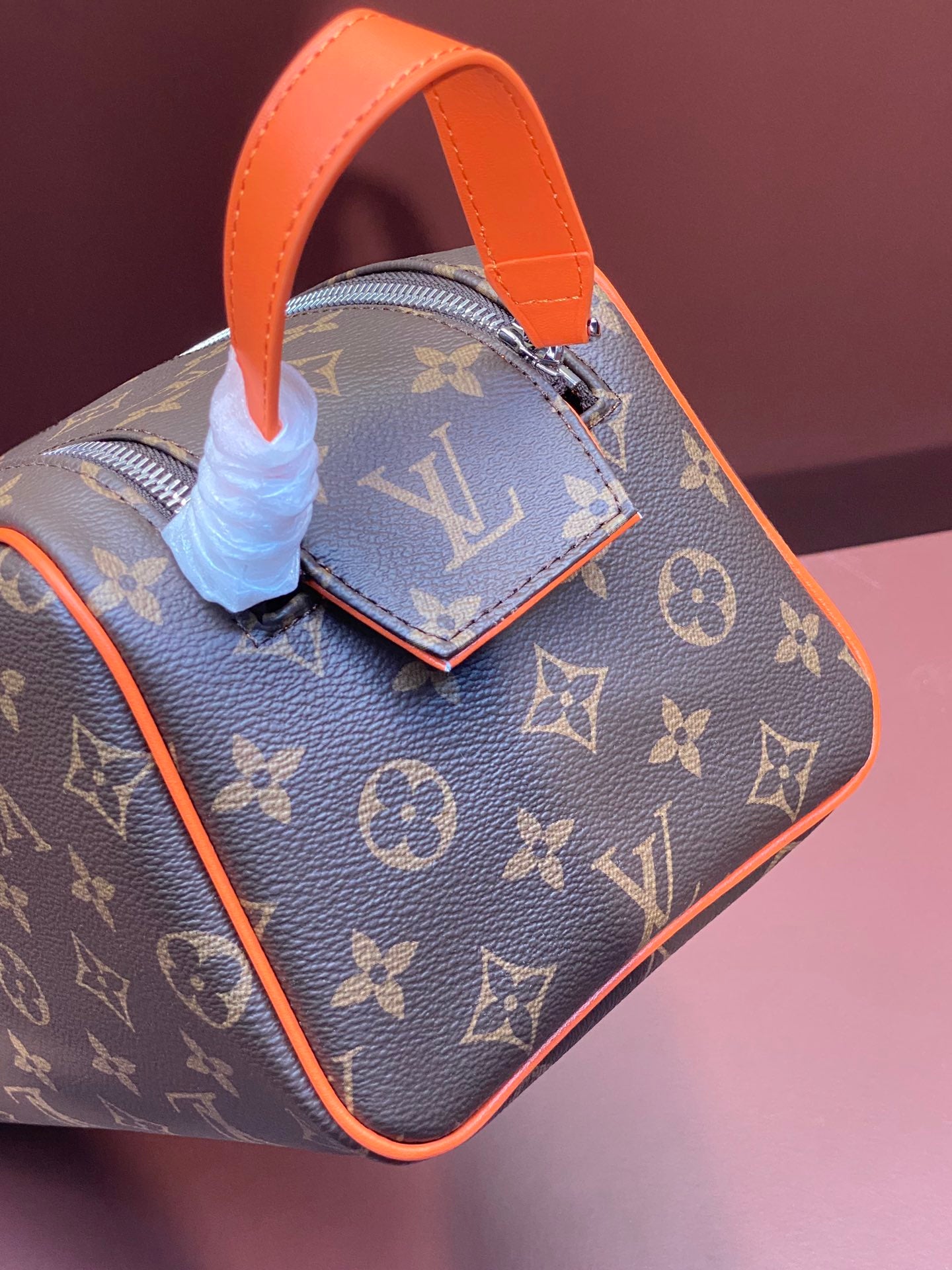 Louis Vuitton monogram bag with orange handle and side pull tabs