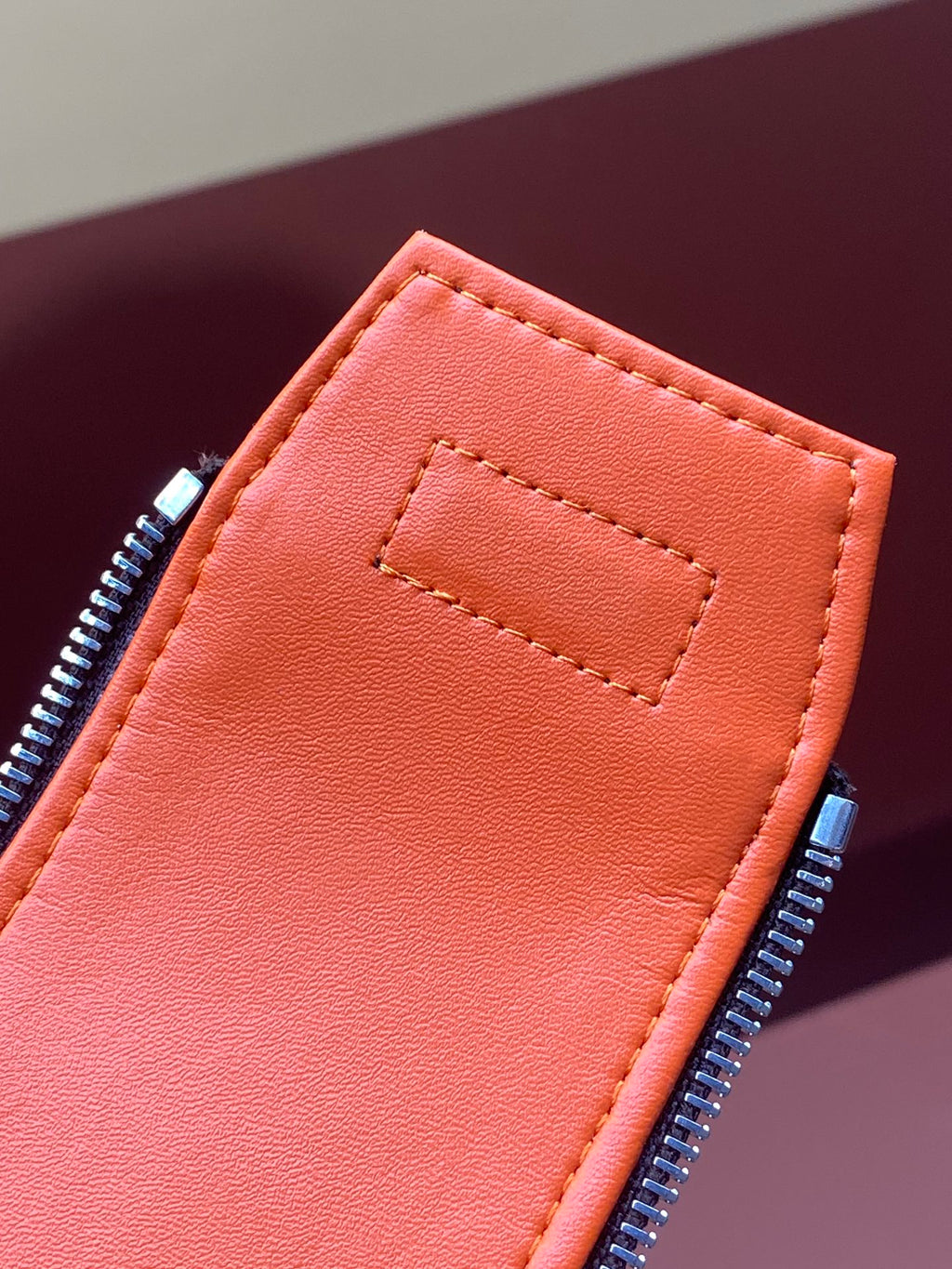 Orange interior zip pocket with stitched edge on Louis Vuitton monogram bag