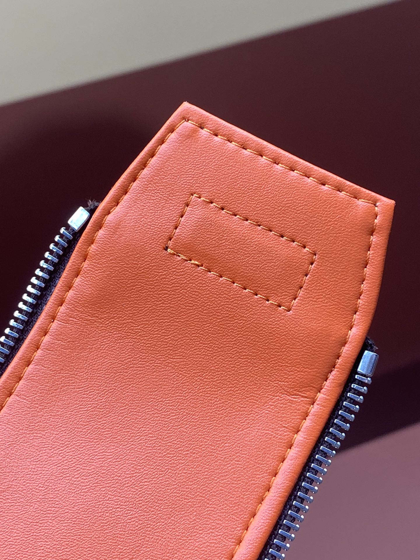Orange interior zip pocket with stitched edge on Louis Vuitton monogram bag