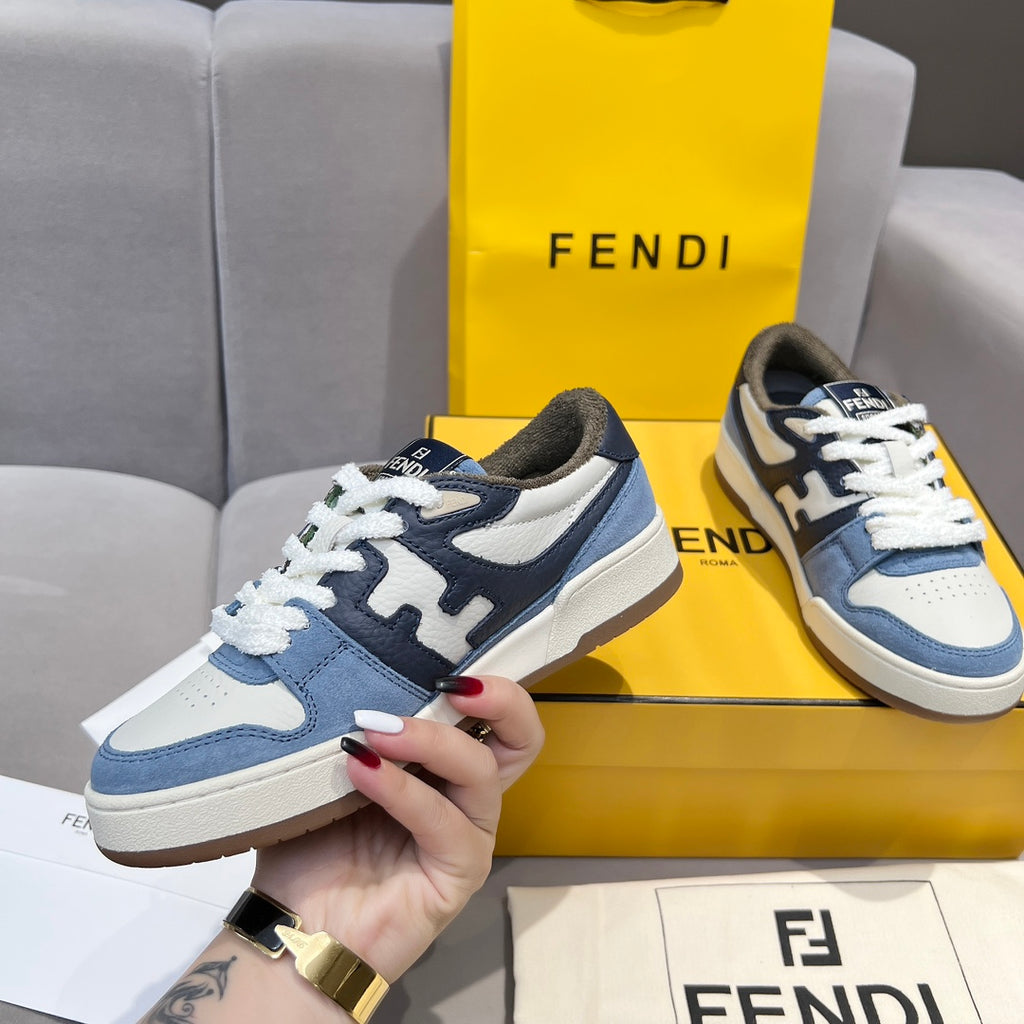 Fendi sneakers in blue and white with white laces and dark logo accent; hand hold
