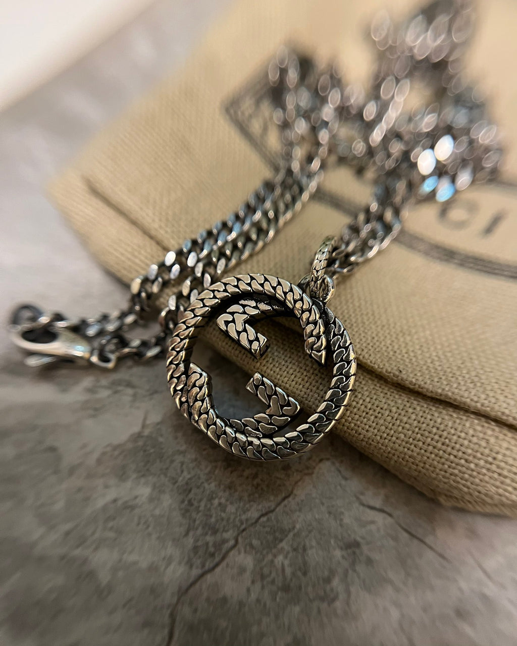 GG heart pendant with braided edge on silver-toned chain necklace