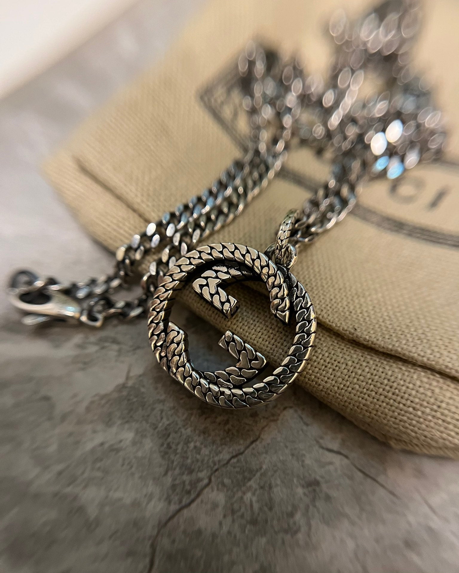 GG heart pendant with braided edge on silver-toned chain necklace