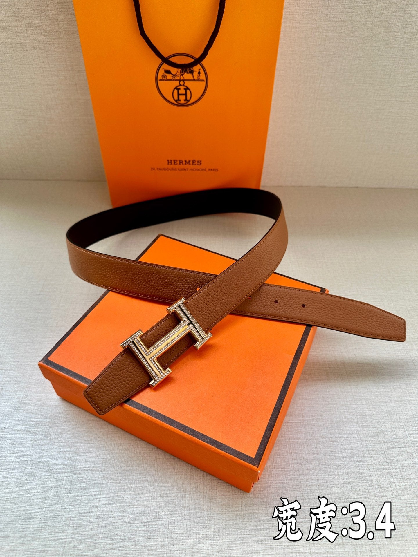 Brown leather belt with silver-toned H buckle and textured leather strap