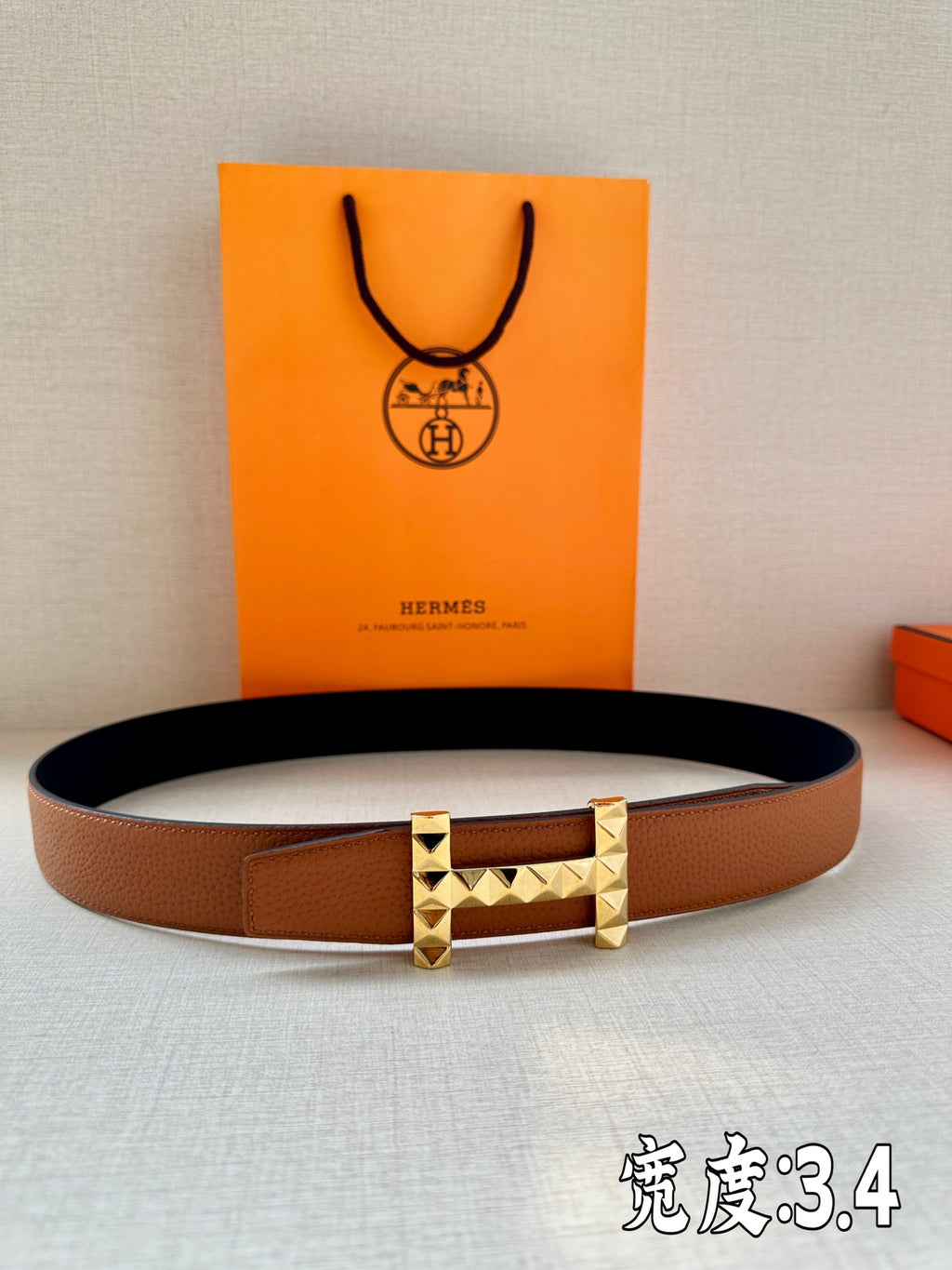 Hermes leather belt with tan-brown strap and gold-tone geometric stud buckle