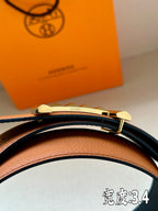 Hermes leather belt close-up with black strap and gold-tone studded buckle