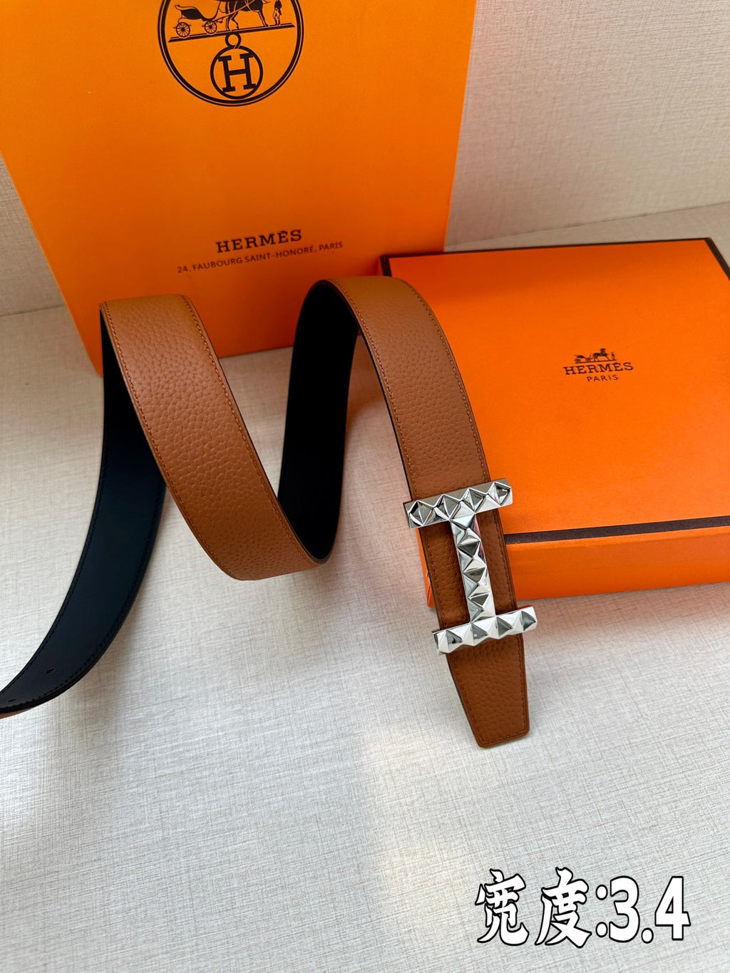 Hermes leather belt with tan-brown strap and silver-tone geometric stud buckle