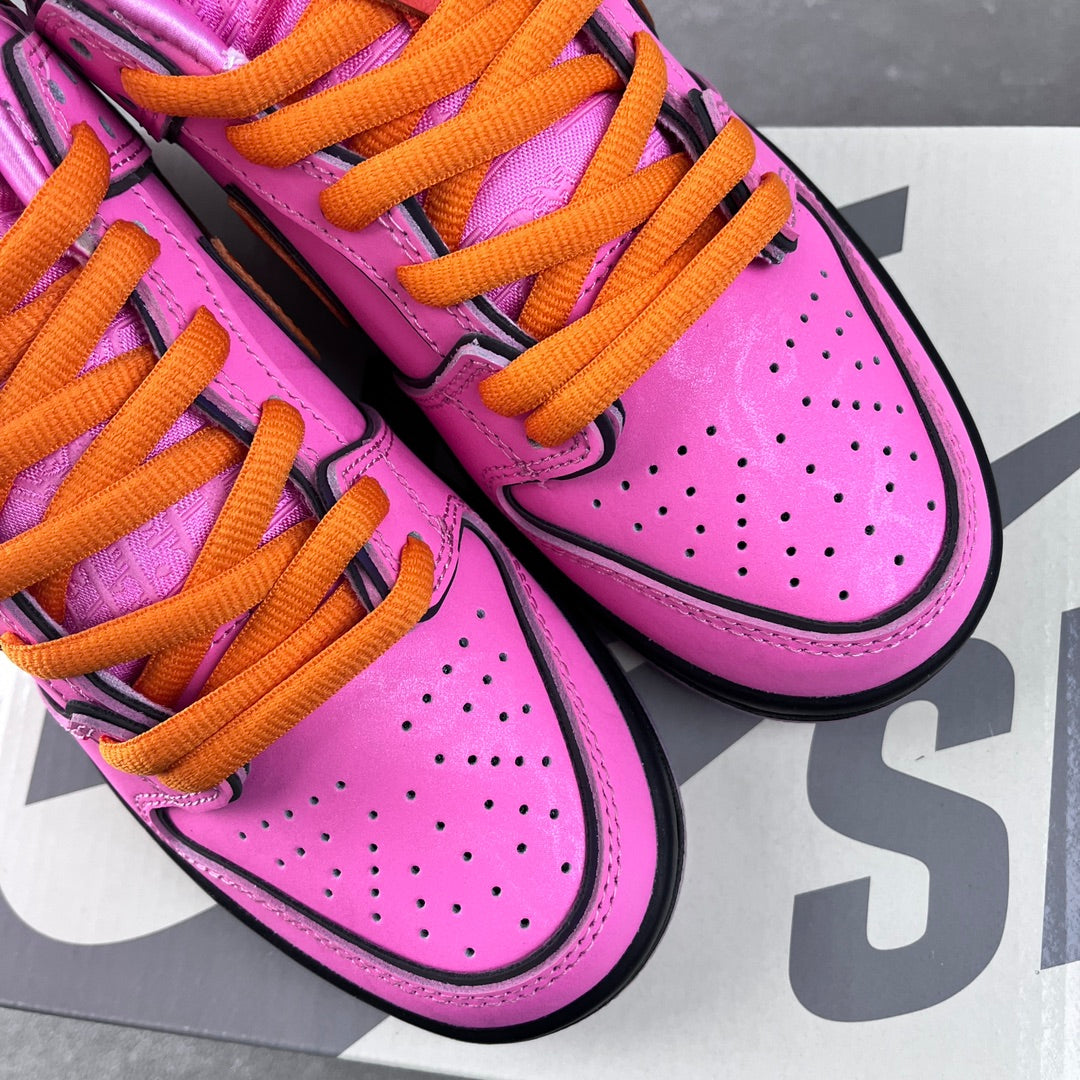 Close-up of pink sneakers with orange laces and perforated toe box with black trim