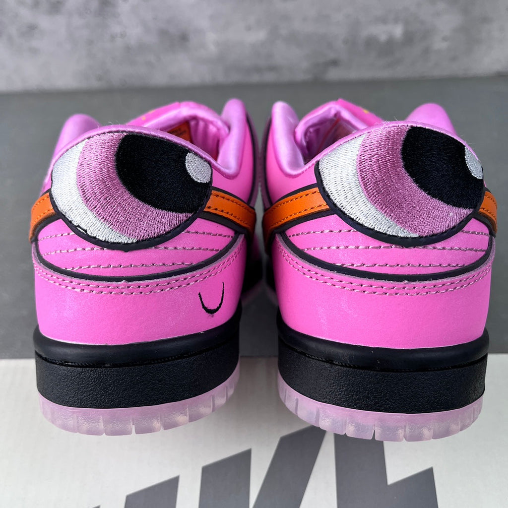 Back view of pink sneakers with black heel and purple lining panels