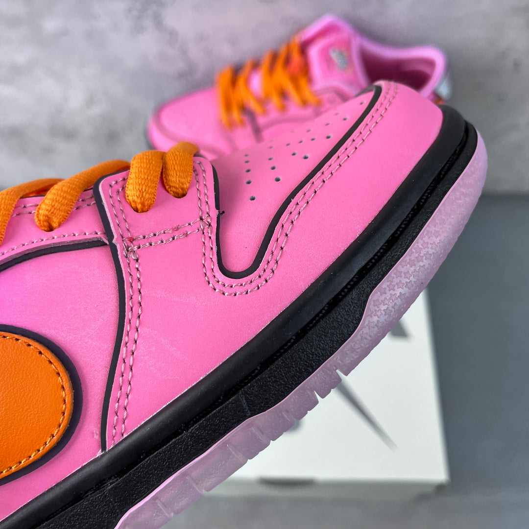 Pink low-top sneaker close-up with orange laces, stitched paneling, and black outsole edge