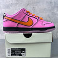 Pink low-top sneakers with orange Nike swoosh, orange laces, and black sole on box