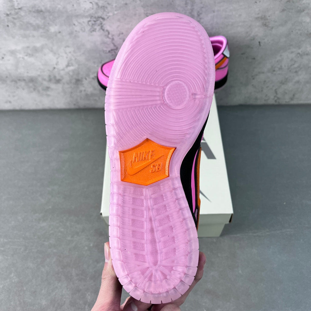 Pink sneaker outsole view with patterned rubber tread and orange heel panel