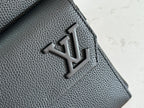 Louis Vuitton leather bag flap with embossed LV logo on textured dark gray leather
