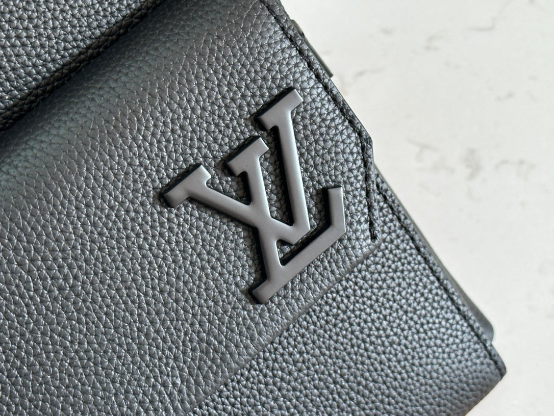 Louis Vuitton leather bag flap with embossed LV logo on textured dark gray leather