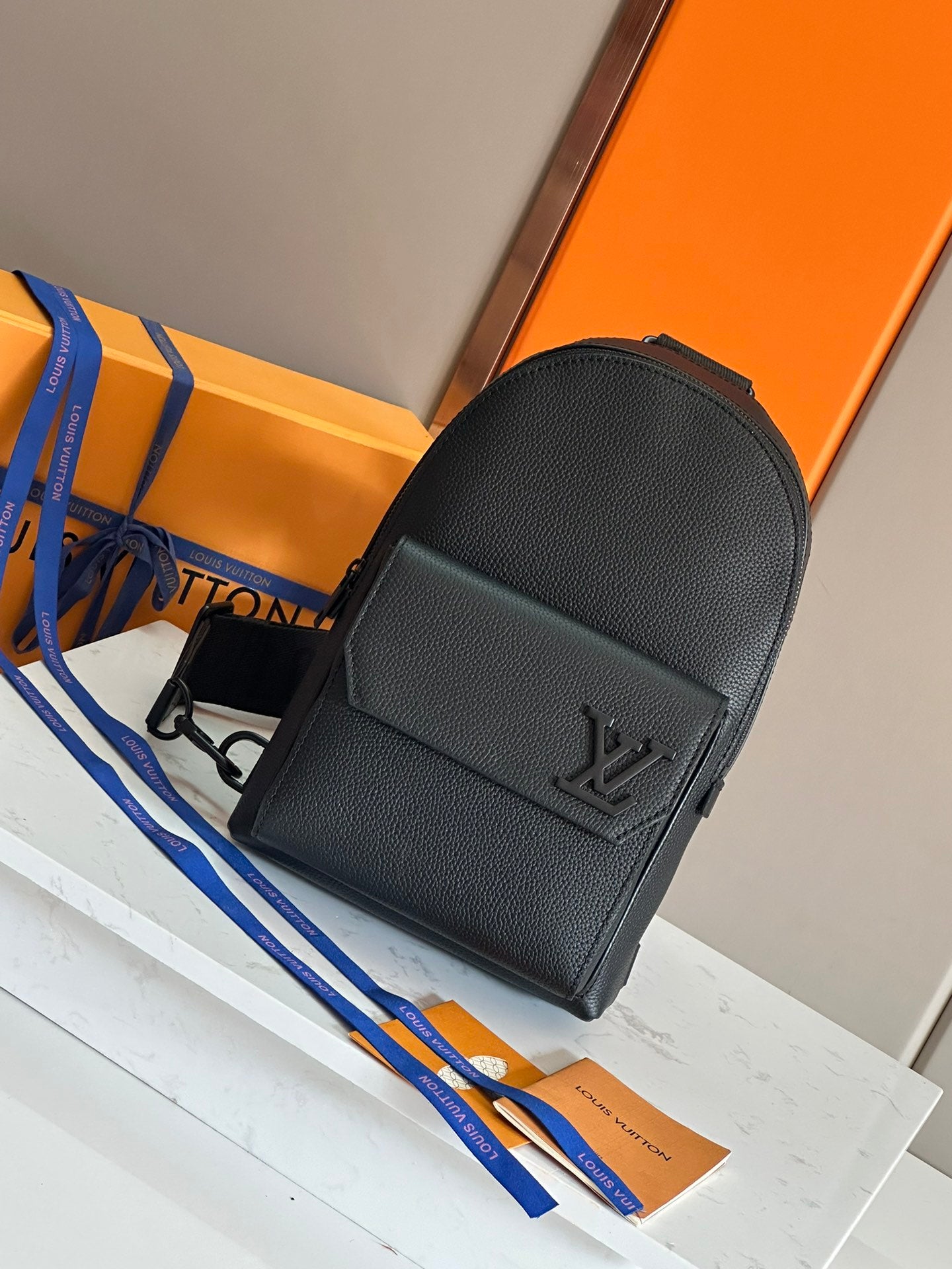 Louis Vuitton mini crossbody bag in dark textured leather with front flap and LV logo