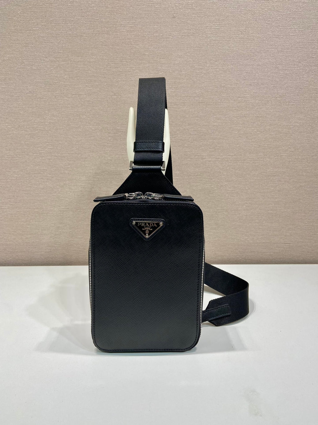 Prada black crossbody bag with flap front, top handle, and adjustable strap