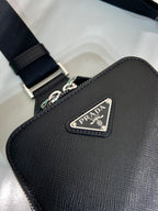 Prada black leather crossbody bag close-up with PRADA triangular logo plaque