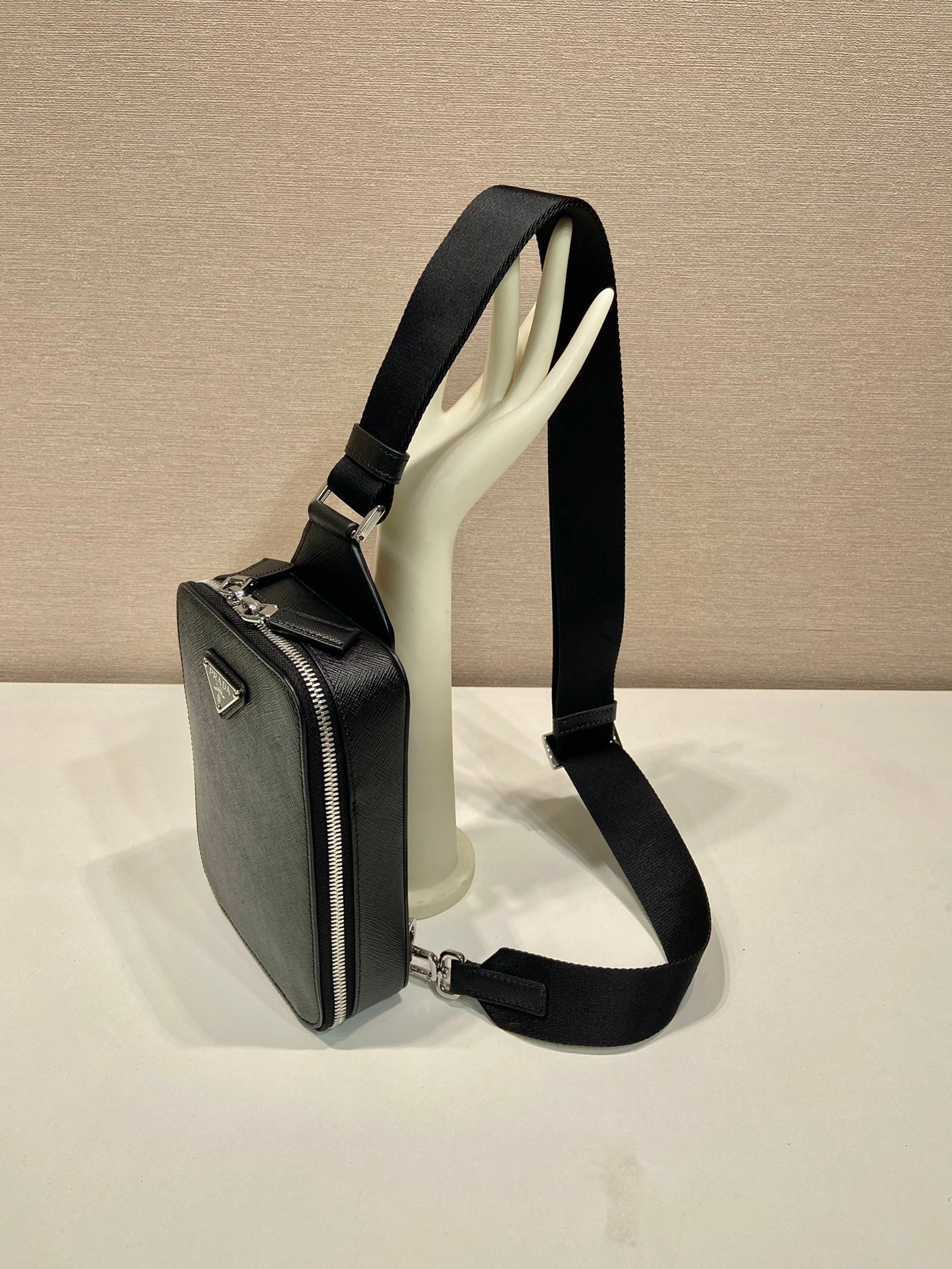 Prada black mini bag on shoulder strap, side profile with zip detail