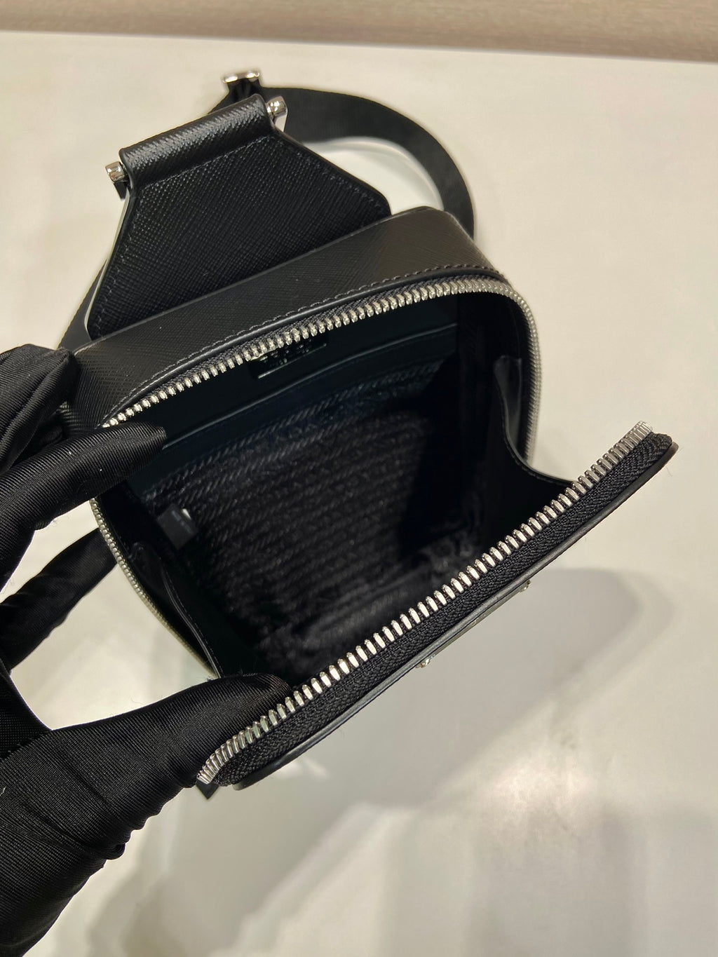Prada black leather crossbody bag interior view with open zipper track