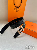 Hermes belt with glossy embossed leather and gold-tone H buckle, angled view