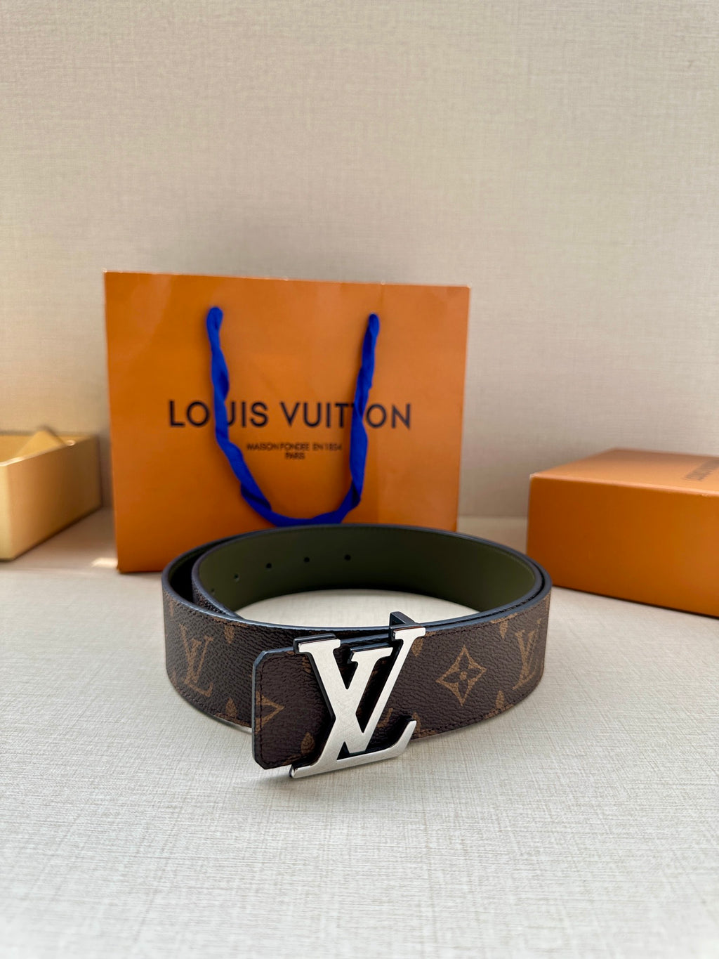 Louis Vuitton monogram belt featuring a gold-tone LV buckle on dark brown canvas