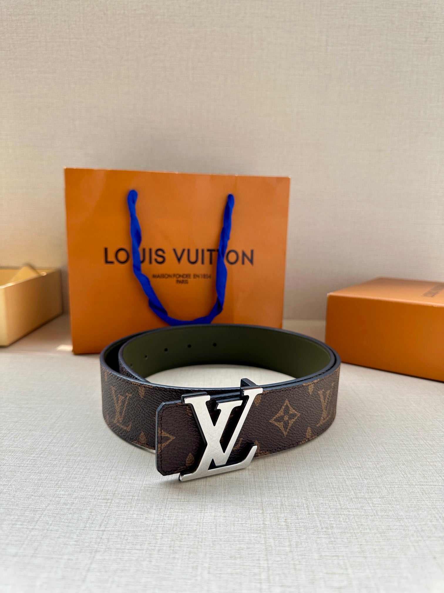Louis Vuitton monogram belt featuring a gold-tone LV buckle on dark brown canvas