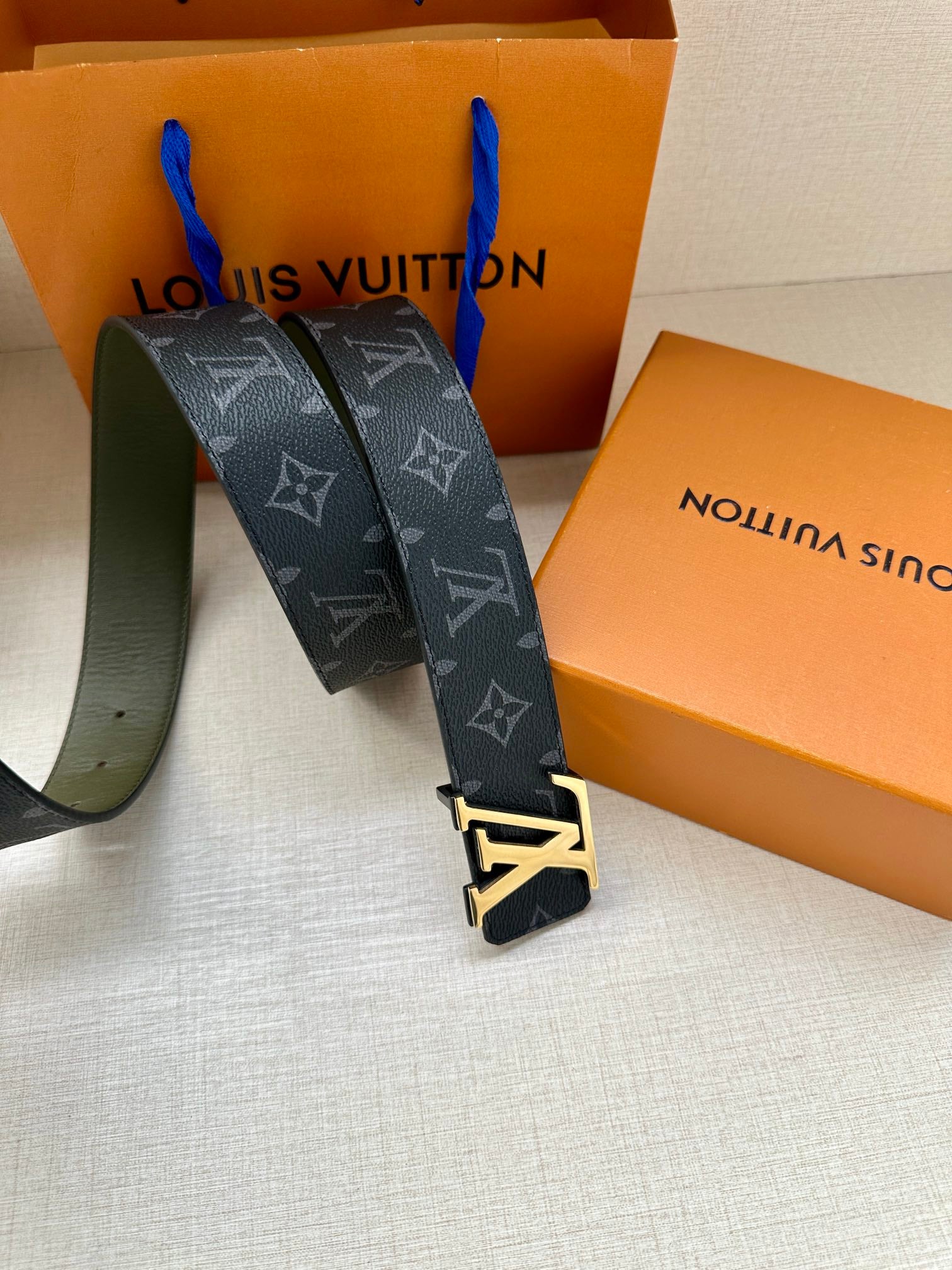 Louis Vuitton monogram belt with LV gold-tone buckle, dark strap and green reverse