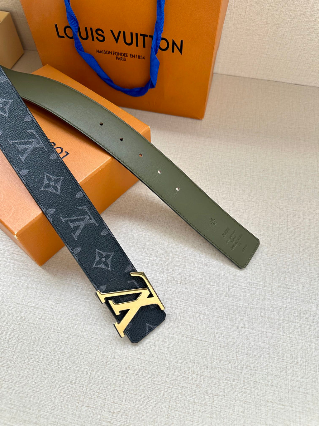Louis Vuitton monogram belt with LV gold-tone buckle, dark blue strap and green reverse