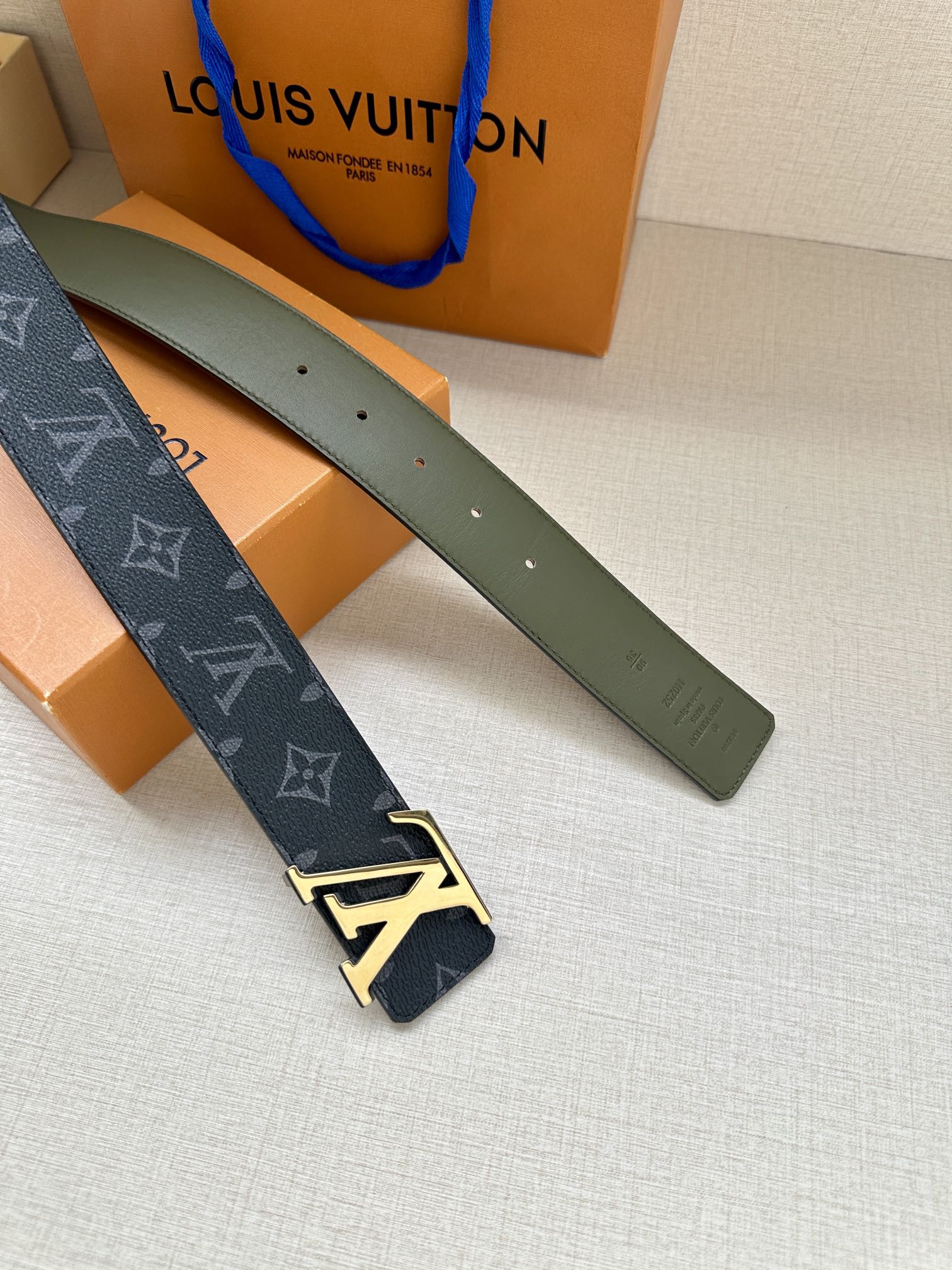 Louis Vuitton monogram belt with LV gold-tone buckle, dark blue strap and green reverse