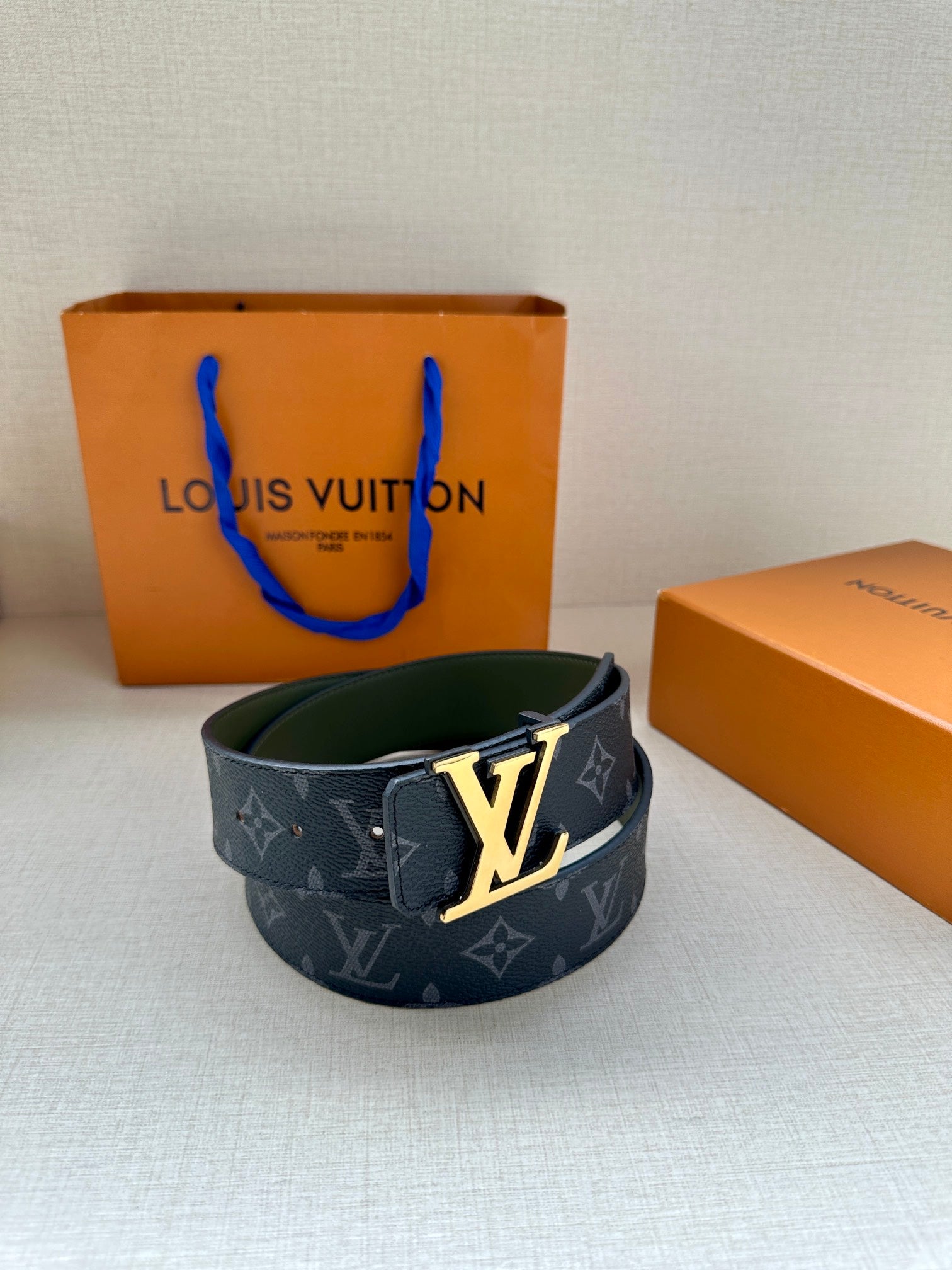 Louis Vuitton monogram belt with LV gold-tone buckle, dark blue strap and green interior