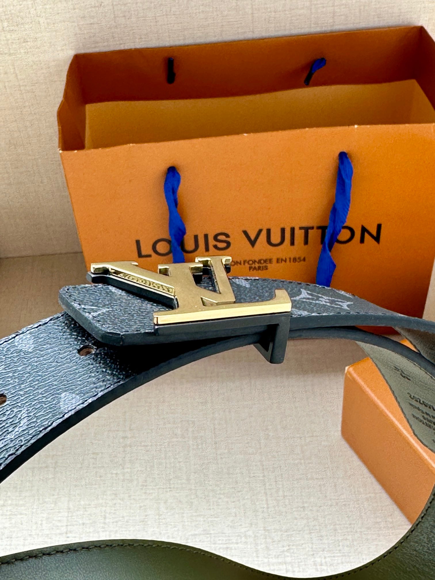 Louis Vuitton monogram belt with LV gold-tone buckle, dark strap and green lining